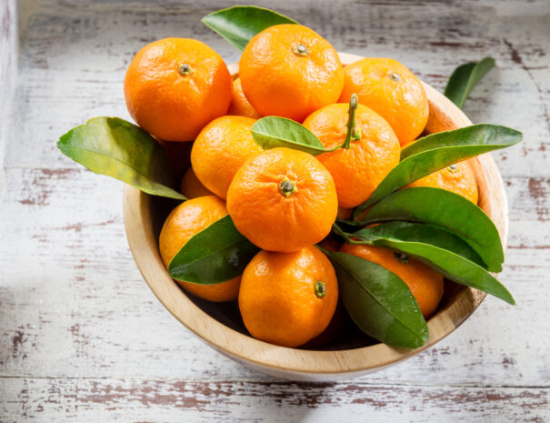 Delicious and beautiful mini Tangerines with leaves in the wooden bowl